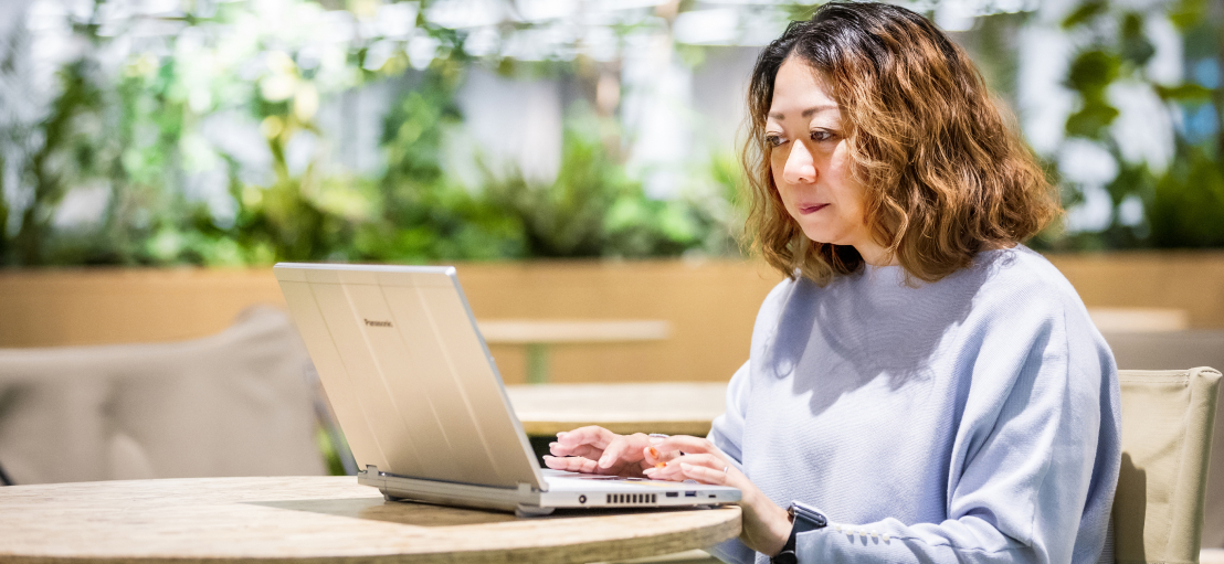 写真：ノートパソコンで仕事をする女性社員