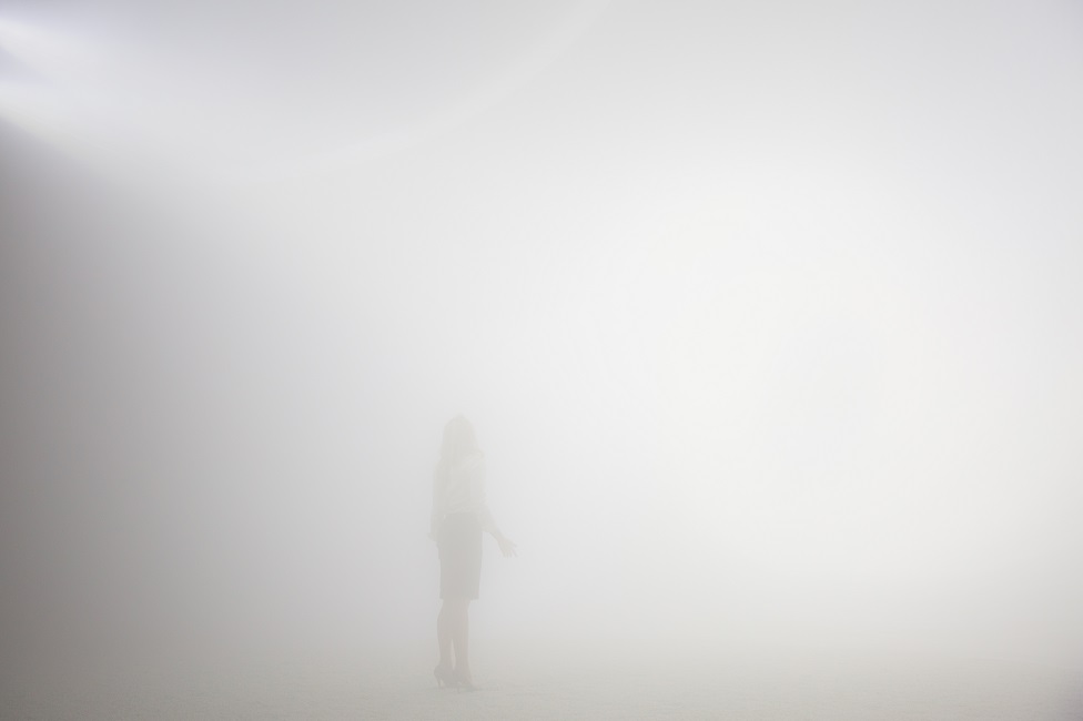 霧で満たされた空間の中で女性が深呼吸している様子